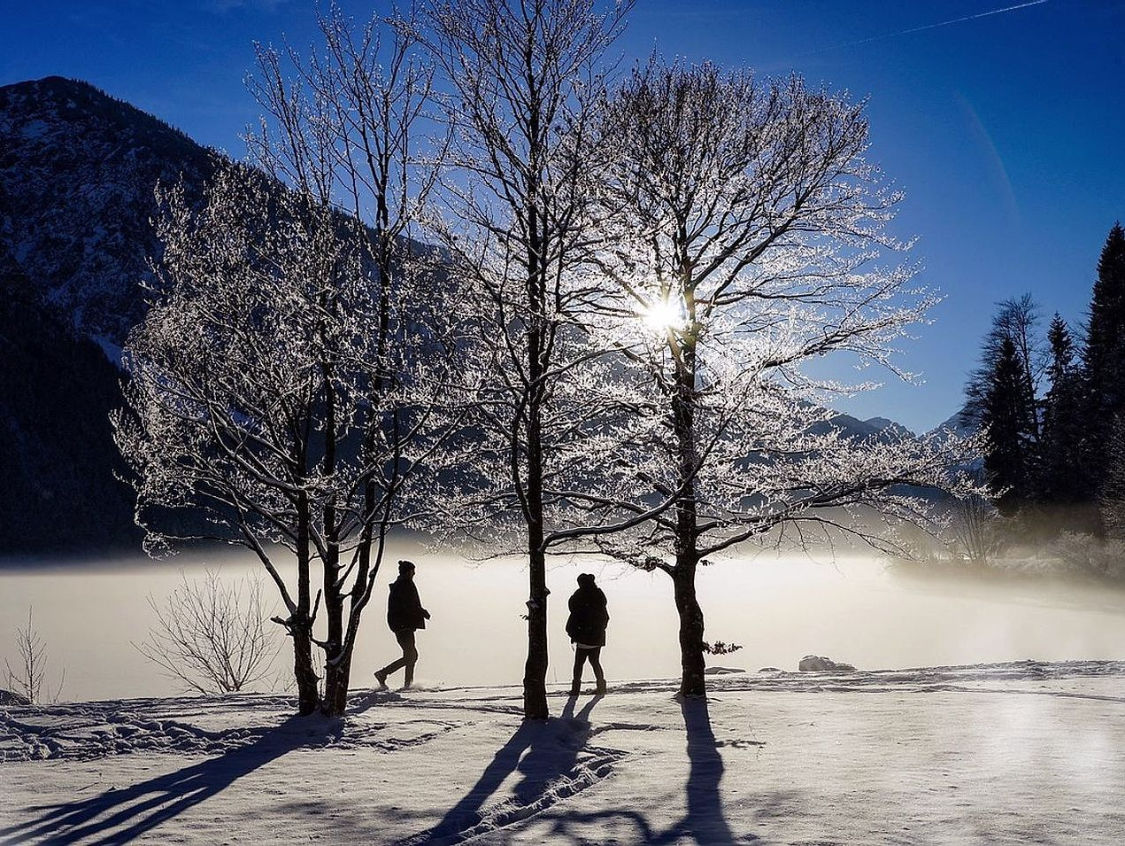 Vista del lago de montaña cubierto de hielo al amanecer